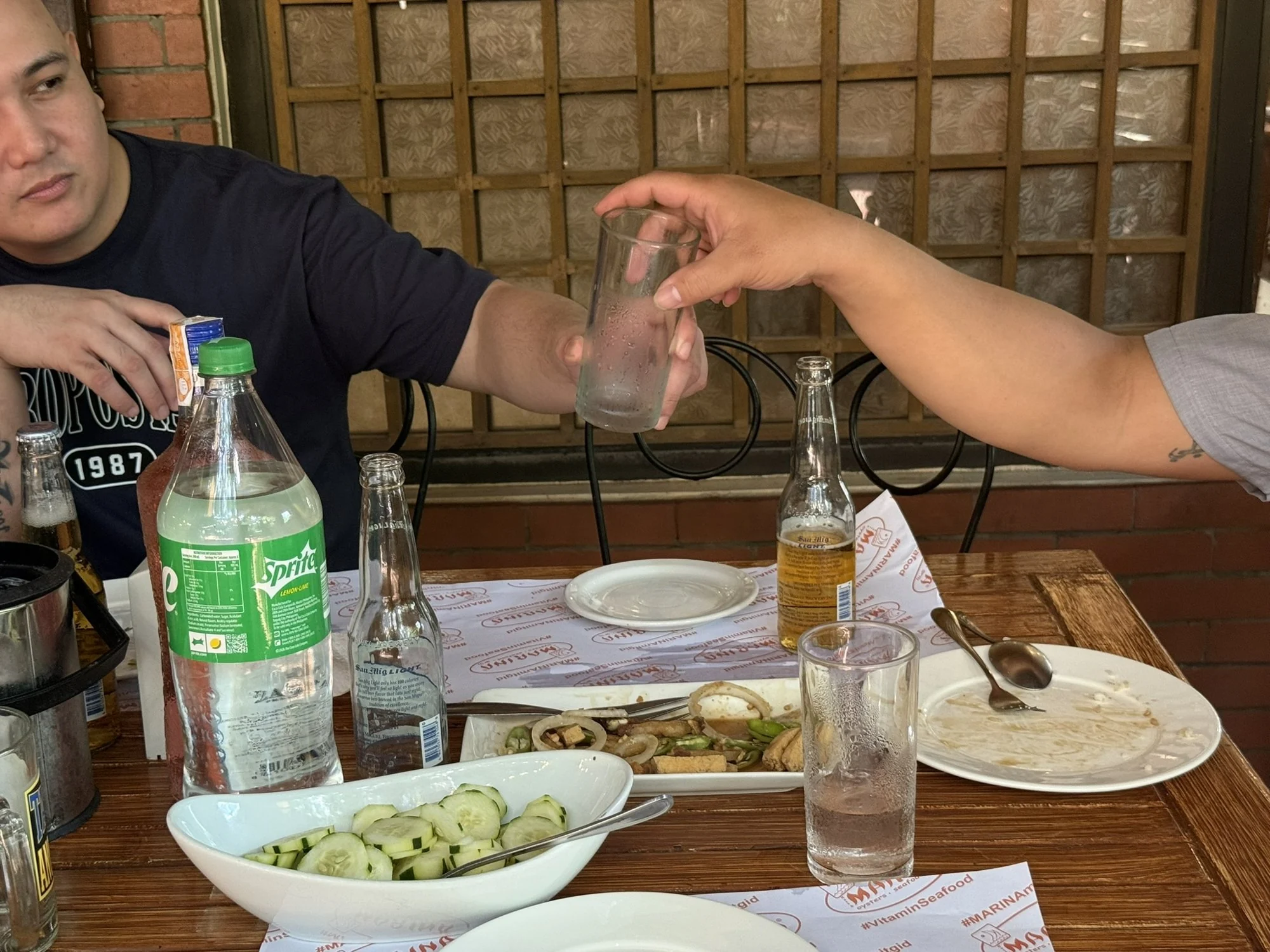 A glass being passed from hand to hand at the table.